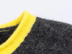 Macro view of the contrast color knit cardigan showing gray and yellow wool texture