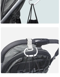 Macro detail of white leather stroller hook with alloy carabiner on handlebar