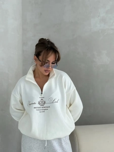 Detail of white half-zip sweatshirt featuring British Heritage print and stand collar