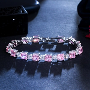 Macro detail of square pink zircon stones and white diamonds on silver plated bracelet