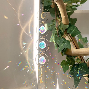 Macro detail of sun catcher with crystal prisms casting rainbow light on a textured wall