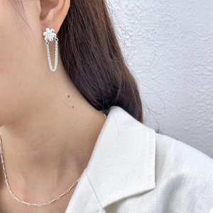 Detailed close-up of 925 sterling silver floral earrings and dainty chain on a model