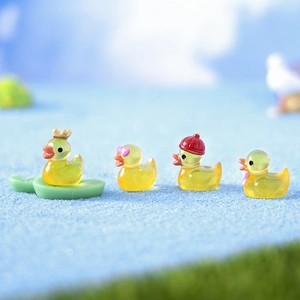 Mini luminous resin ducks with accessories on blue sand for desktop decoration