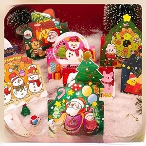 Close-up of assorted Kraft paper Christmas tags featuring cartoon Santa and Reindeer designs