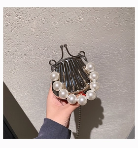 Detail der silbernen Muscheltasche mit Perlengriff und feinem Metallkettenriemen