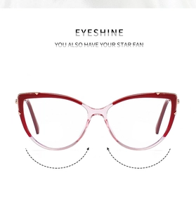 Detail view of cat eye glasses frame with red gradient finish and gold metal accents