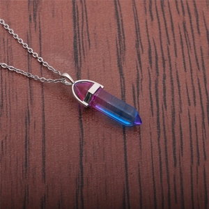 Macro view of gradient pink and blue hexagonal crystal prism pendant with silver chain