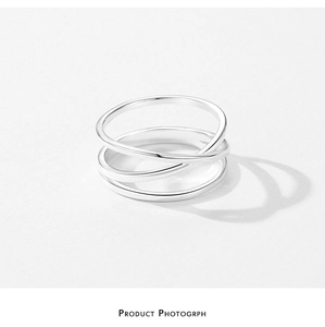 Macro view of geometric triple-layered silver crossover ring with polished finish