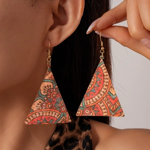 Gros plan de boucles d'oreilles triangulaires aux motifs ethniques portées par un mannequin