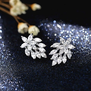 Macro shot of marquise-cut crystal leaves earring on a starry blue background