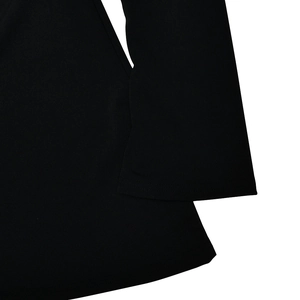 Detailed macro view of the black knitted fabric texture and fine stitching on the dress hem