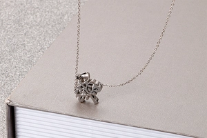 Close-up of a silver Tree of Life hollow pendant on a stainless steel necklace chain