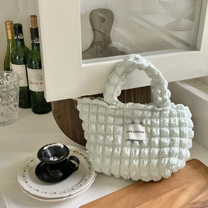 Detail of mint green quilted puffer handbag featuring a unique bubble texture design