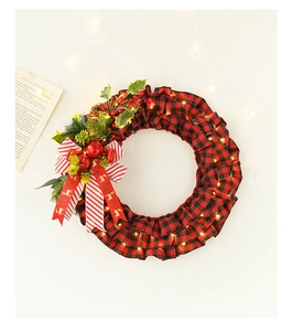 Detail of Christmas wreath with red berries, pine cones and warm LED lights