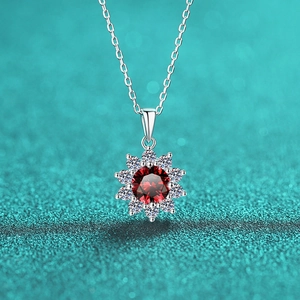 Macro detail van zonnebloem hanger met rode edelsteen en zilveren ketting