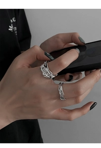 Close-up of liquid metal style irregular silver rings set worn on a hand