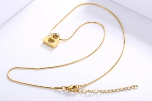 Close-up of golden heart-shaped hollow padlock pendant on a sleek snake chain necklace