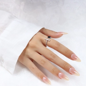 Close-up of minimalist silver open ring with black round stone on a model's finger