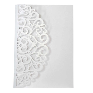 Close-up of white pearlescent paper wedding invitation with laser-cut lace pattern