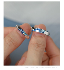 Macro shot of silver couples rings featuring blue starry sky enamel and moon detail