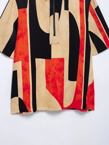 Detail of short-sleeved shirt featuring abstract geometric patterns and zip-up stand collar