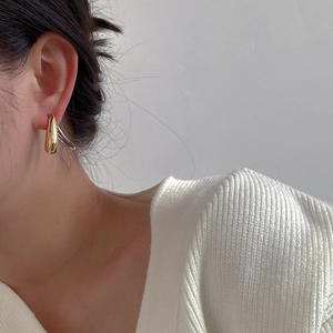 Fashionable 925 silver needle drop earrings with two-tone gold and silver finish on model