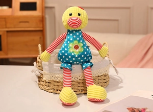 Detail of a colorful plush long-legged duck doll in a woven basket with warm home decor