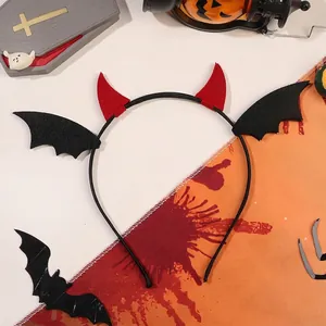 Gothic Halloween headband detail with red devil horns and black bat wings on black frame