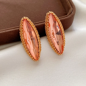 Elegant peach marquise-cut crystal earrings with gold beaded edges on velvet display