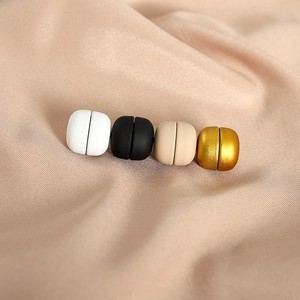 Magnetic hijab clips in black, white, beige, and gold on soft silk fabric