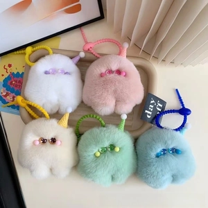 Close-up of colorful plush monster keychains in five pastel shades with silicone straps