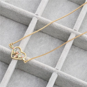 Golden heart necklace with colorful zircon heartbeat design on a jewelry display box