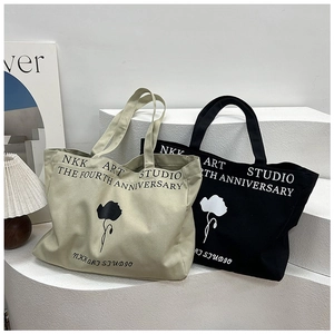 Detail of floral print and typography on large canvas tote bags in beige and black