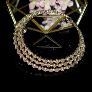 Detail of elegant triple-layer gold choker necklace with sparkling clear rhinestones