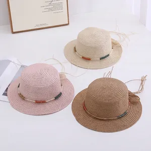 Flat lay of wide brim girls straw hats in pink, beige and camel with tassel band decoration
