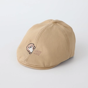 Détail de la broderie loutre et du texte sur un béret en coton beige pour bambin