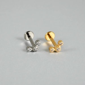 Détail de piercings labret en titane G23 avec trois zircons en doré et argenté