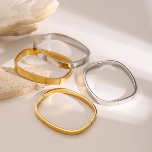 Detailed close-up of square stainless steel bangles in gold and silver finish