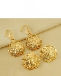 Detail of sunflower earrings with 18K gold vacuum plating on a golden silk background
