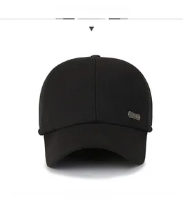 Detail view of a black wool baseball cap featuring a premium silver metal brand logo tag