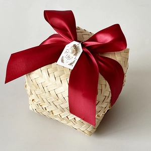 Detail of handmade bamboo gift box with red satin ribbon and pearl thank you tag