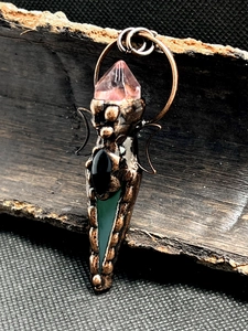 Macro view of vintage bronze double moon pendant with amethyst and colorful agate stones