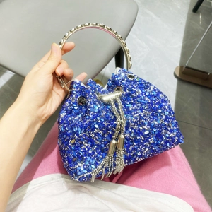 Close-up of blue rhinestone bucket bag featuring metal ring handle and tassel details