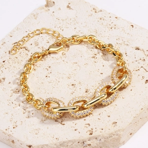 Macro shot of gold hip hop chain with four pavé-set diamond oval links on stone