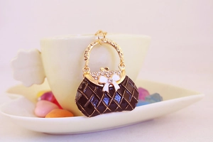 Close-up of brown plaid bow bag keychain with sparkling rhinestones and gold accents
