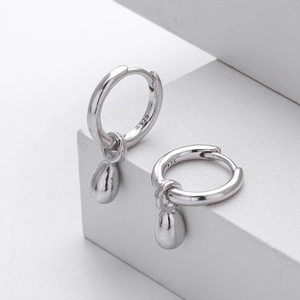 Macro shot of S925 sterling silver hoop earrings with polished water drop pendants