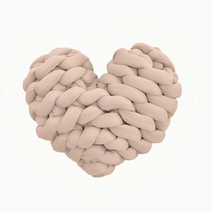 Detailed view of handmade chunky knit heart pillow in beige with woven texture and soft yarn