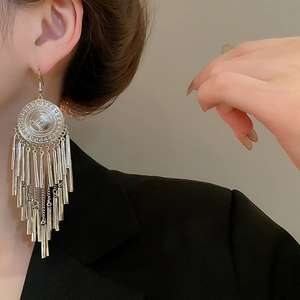 Silver round embossed drop earrings with long metal tassels on model with black suit