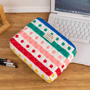 Detailed macro view of a colorful polka dot quilted cotton makeup bag with zip closure