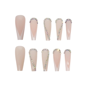 Macro detail of long coffin nude pink press-on nails with French tips and rhinestones